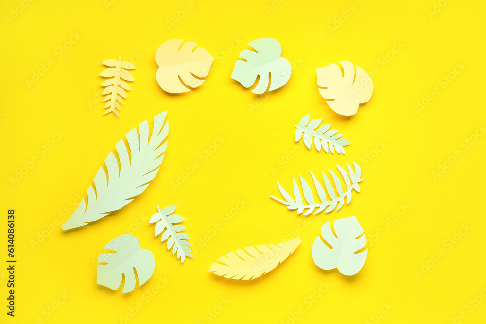 Frame made of paper tropical leaves on yellow background