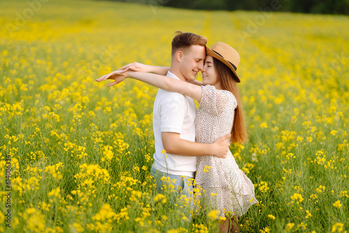 Young Couple in the blooming field. Nature, vacation, love, relax and lifestyle. Summer landscape. © maxbelchenko