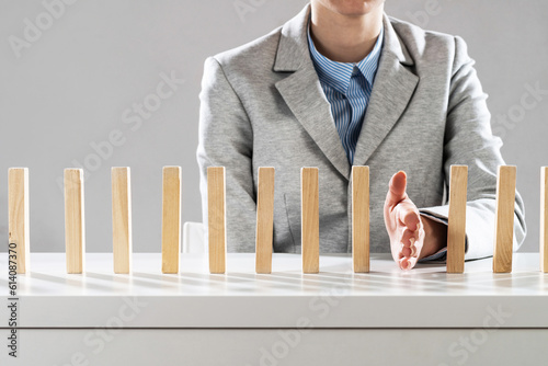 Business woman hand stop domino effect
