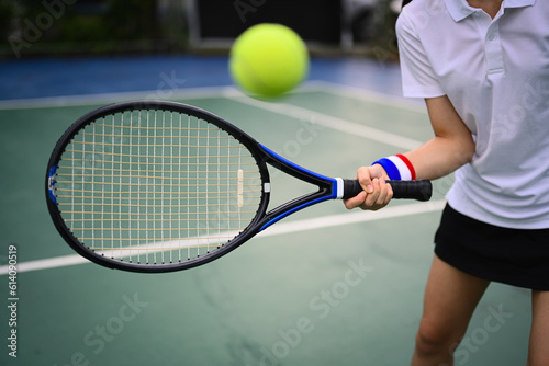 Shot of tennis player hitting ball with racket to return ball over net. Sport, fitness, training and active life concept © Prathankarnpap