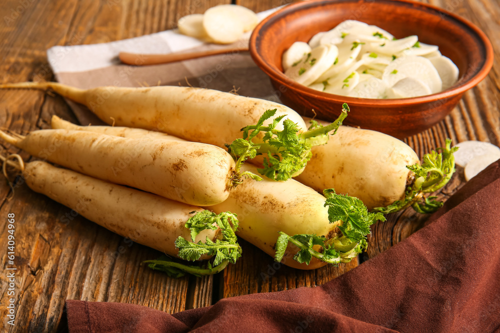 Bowl with slices of fresh daikon radish on wooden background Bowl with slices of fresh daikon radish on wooden background