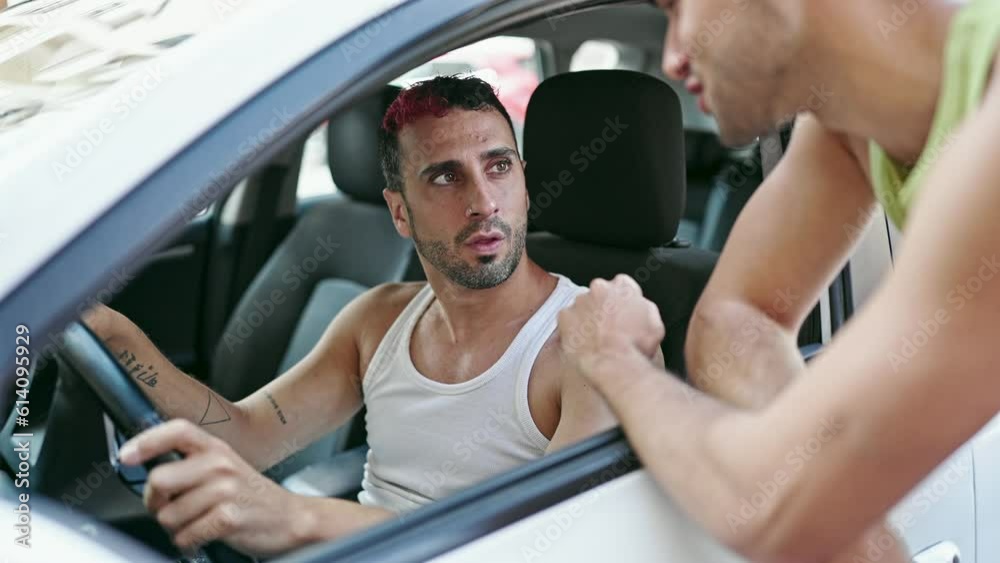 Two men sitting on car speaking at street Two men sitting on car speaking at street