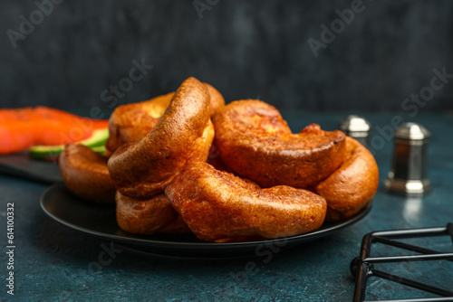 Plate with tasty Yorkshire pudding on blue background