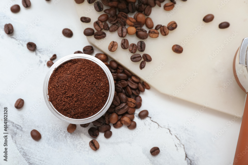 Bowl with coffee powder and beans on white marble background Bowl with coffee powder and beans on white marble background
