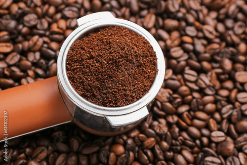 Portafilter with coffee powder and beans, closeup