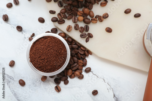 Bowl with coffee powder and beans on white marble background