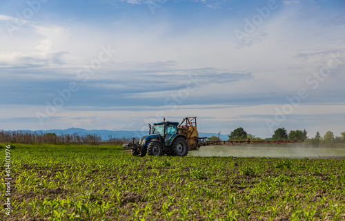 Agricultural tractor spraying field
