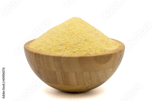 Dry organic semolina flour isolated on white background. Uncooked organic semolina in wooden bowl
