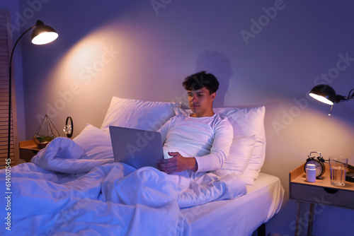 Young man using laptop in b...