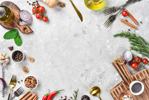 Fototapeta Naklejka Na Ścianę i Meble -  Cooking background: vegetables, spices and kitchen utensils on the table. On a gray stone background. Restaurant menu.
