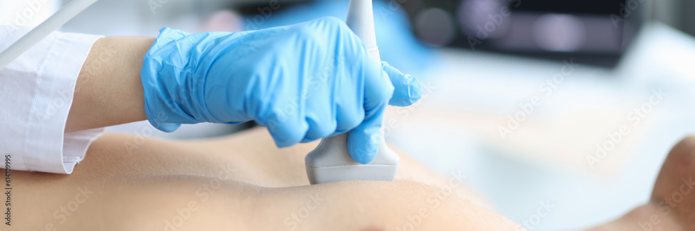 Doctor makes echocardiography of male patient using ultrasound probe pressing on patient chest. Ultrasound of heart in man concept