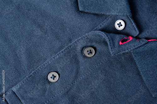 Fragment of a blue T-shirt with a collar and button fastening.