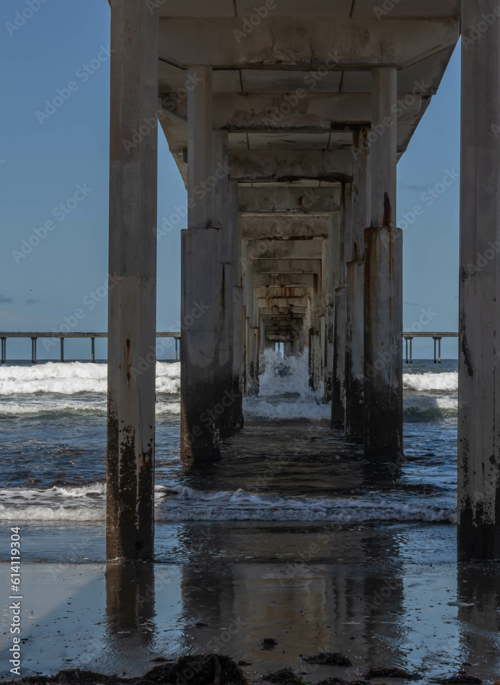 Looking Through Underside of Concrete Pier with Waves Crashing onto Support Pylons, Ocean Beach, California, USA, vertical
