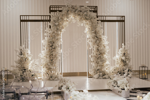 Obraz na płótnie Wedding arch decorated with white flowers in the luxury restaurant. Beautiful wedding set up in the luxury locale. w salonie