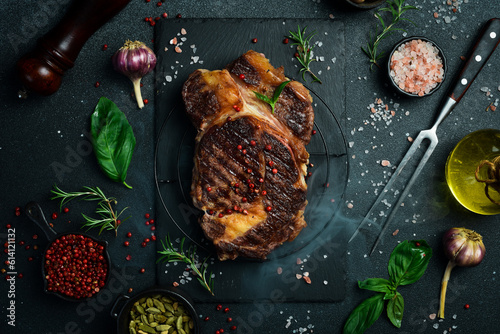 Grilled veal steak with rosemary on a stone slate surface. Top view with copy space. Flat lay