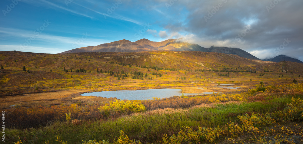 Mountain landscape with little lake in panorama format in autumn colors, Yukon territory Canada
