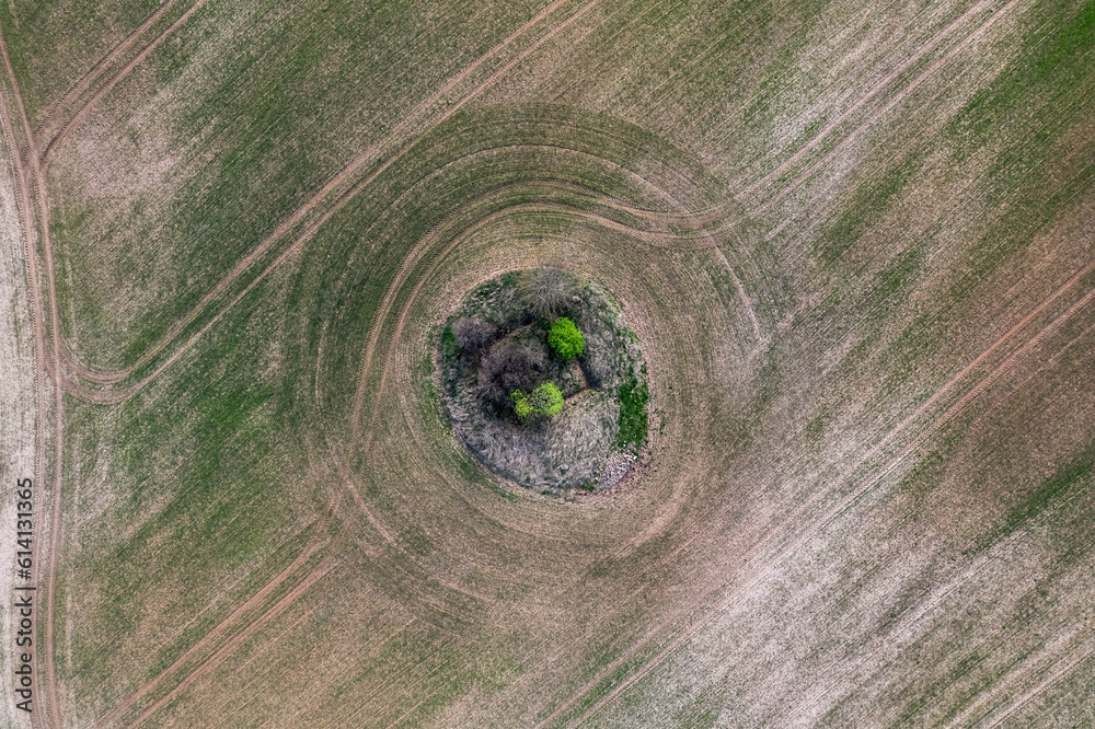 aerial view of a grass field with a ruins in the middle aerial view of a grass field with a ruins in the middle