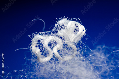 Extreme macro of polyester stable fiber on blue background photo