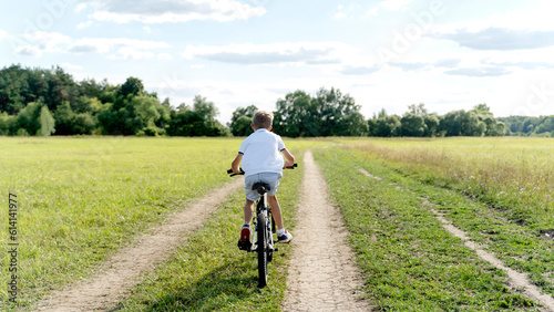 a boy rides a bicycle in nature