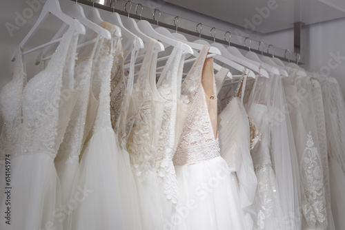 Assortment of dresses hanging on a hanger on the background studio. Fashion wedding trends.