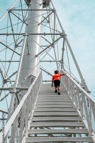 Young boy climbs stairs of unique public lighthouse at Port San Blas in Port St. Joe, Florida