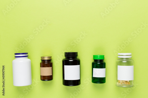 Plastic bottles with vitamins on color background, top view