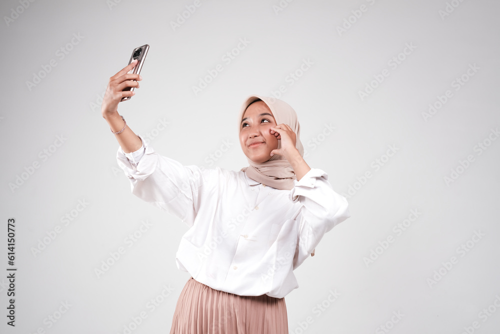 Asian muslimah take a selfie with her phone Asian muslimah take a selfie with her phone