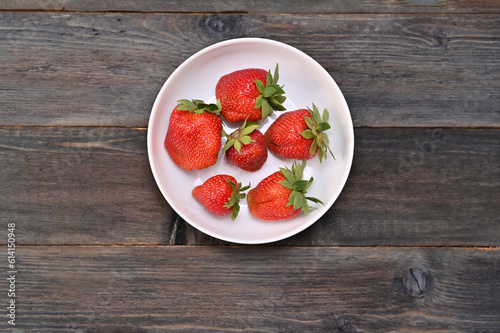 Juicy strawberries on a white plate.