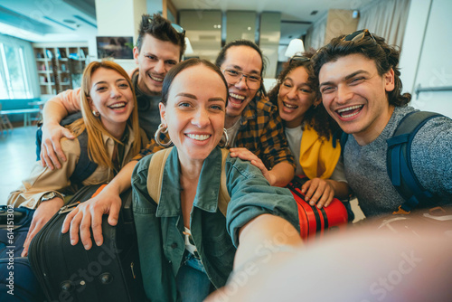 Group of young tourists standing in youth hostel guest house - Happy multiracial friends booking summer vacation home - Guys and girls having fun taking selfie picture at summertime holidays