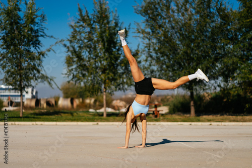 A photo of sporty girl doing a cartwheel