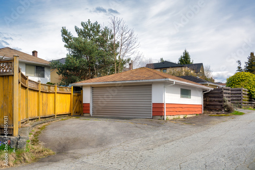 Detached garage of residential house with asphalt road in front