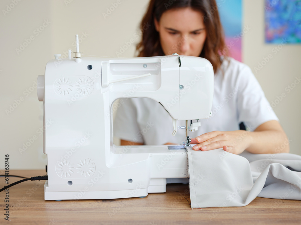 Fashion, fabric and sewing, woman at machine in small business with creative ideas and focus at home studio. Creativity, startup and design, tailor or designer stitching, young entrepreneur at work.