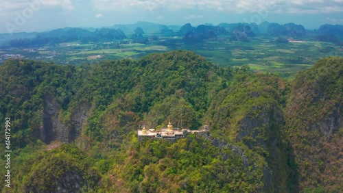 Aerial view Tiger Cave Temple, Buddha on the top Mountain with blue sky of Wat Tham Seua, Krabi,Thailand. Aerial view 4K.