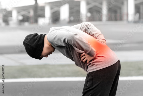 Man is suffering from lower back pain outdoors. 