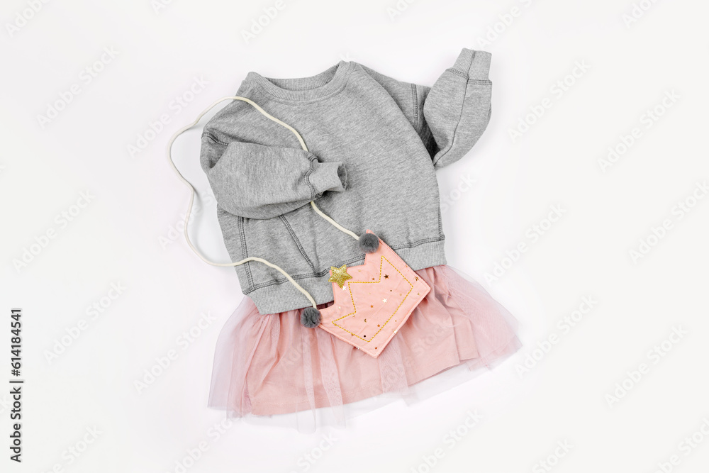 Fashion kids dress with cute bag on white background. Stylish children's clothes for spring. Trendy outfit. Flat lay, top view Fashion kids dress with cute bag on white background. Stylish children's clothes for spring. Trendy outfit. Flat lay, top view