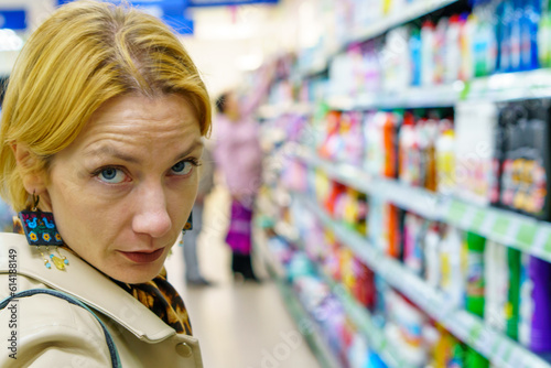 Grodno, Belarus June 21, 2023: A girl buyer in a non-food store examines the goods and makes purchases. Visitors at the mall. Free Download Grodno, Belarus June 21, 2023: A girl buyer in a non-food store examines the goods and makes purchases. Visitors at the mall. - GFXLoad