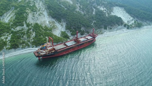 Aerial view of abandoned cargo ship. Bulk carrier ran aground after the storm. Dry cargo ship stands ashore.