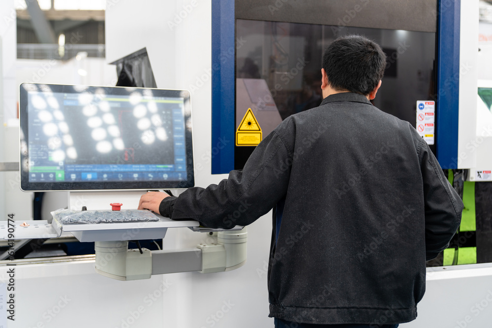 Worker controls automatic machine tool in smart factory.