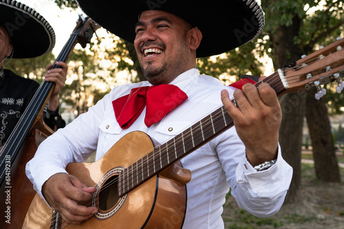 Mexican musician mariachi plays the guitar on a city street.