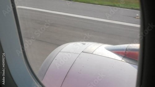 view through the aircraft airplane window to the plane's engine while running over runway and Take off from the airport over bangkok city metropolis photo