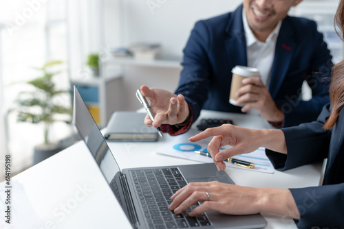 Meeting of business people pointing at graphs and charts to analyze market data. Group of businesspeople meeting together analyzing and pointing laptop about business growth.