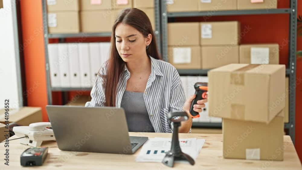 Young beautiful hispanic woman ecommerce business worker scanning package using laptop at office Young beautiful hispanic woman ecommerce business worker scanning package using laptop at office