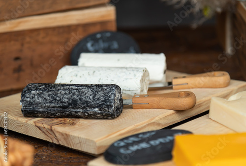 Queso de Cabra, color negro y blanco sobre tabla de madera con cuchillo de corte