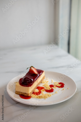 A piece of Strawberry cheesecake served on plate with sauce and crumble