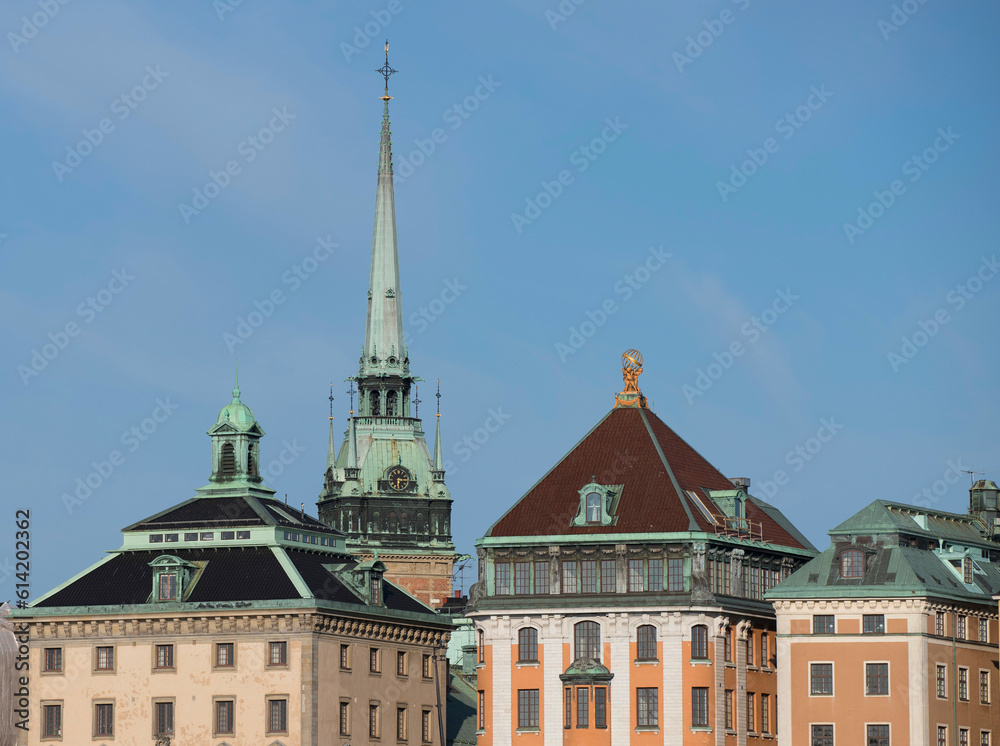 Fototapeta premium Clock tower of the German church and old houses in the old town Gamla Stan, a sunny summer morning in Stockholm