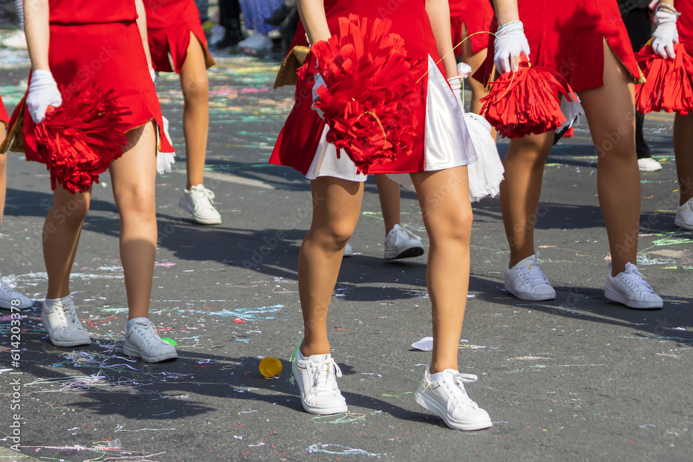 Foto de Cheerleaders in red white uniform with pompoms marching at