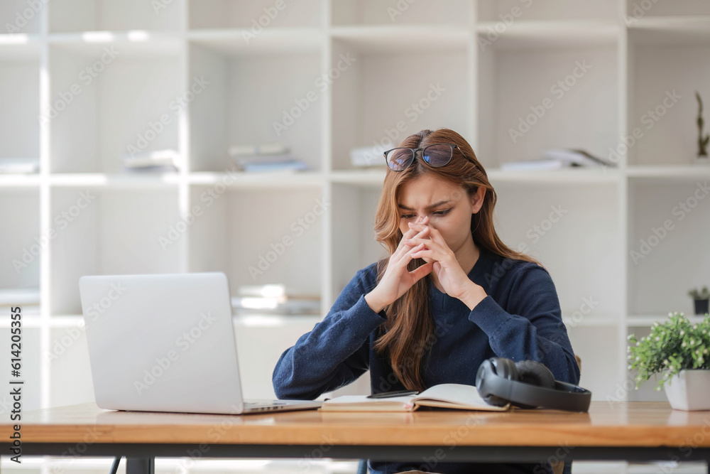 Asian women are bored from their online studies, have a sad face and have been tired from their studies for a long time.
