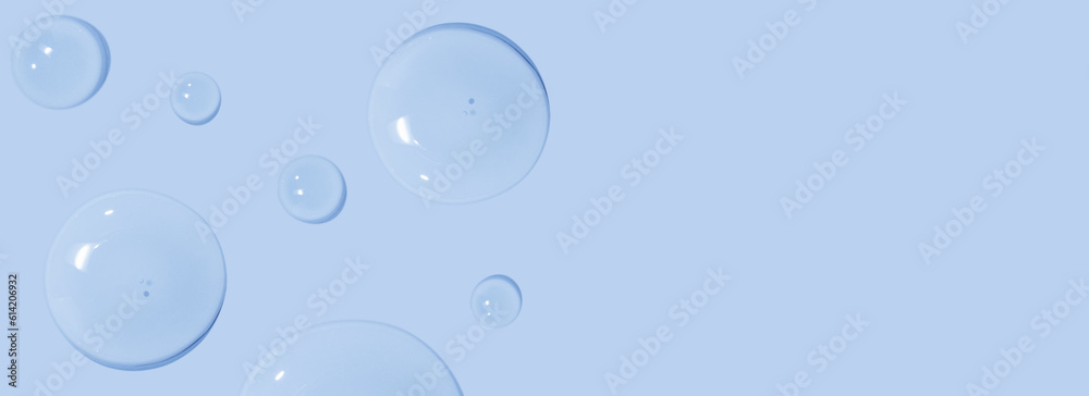 large drops of cosmetic serum, liquid, water, gel on a pink background