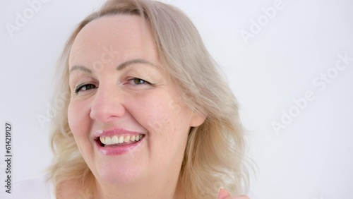 blonde woman dancing waving hands turns her head left and right laughing dancing shrugs her shoulders on a white background making eyes sexy 