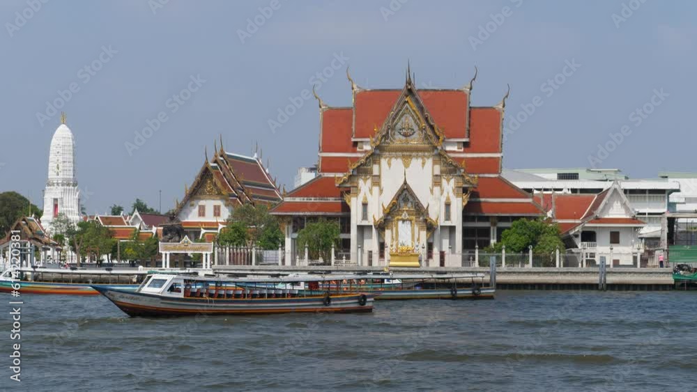 Details of Temple in Bangkok from the river with boats passing by Details of Temple in Bangkok from the river with boats passing by